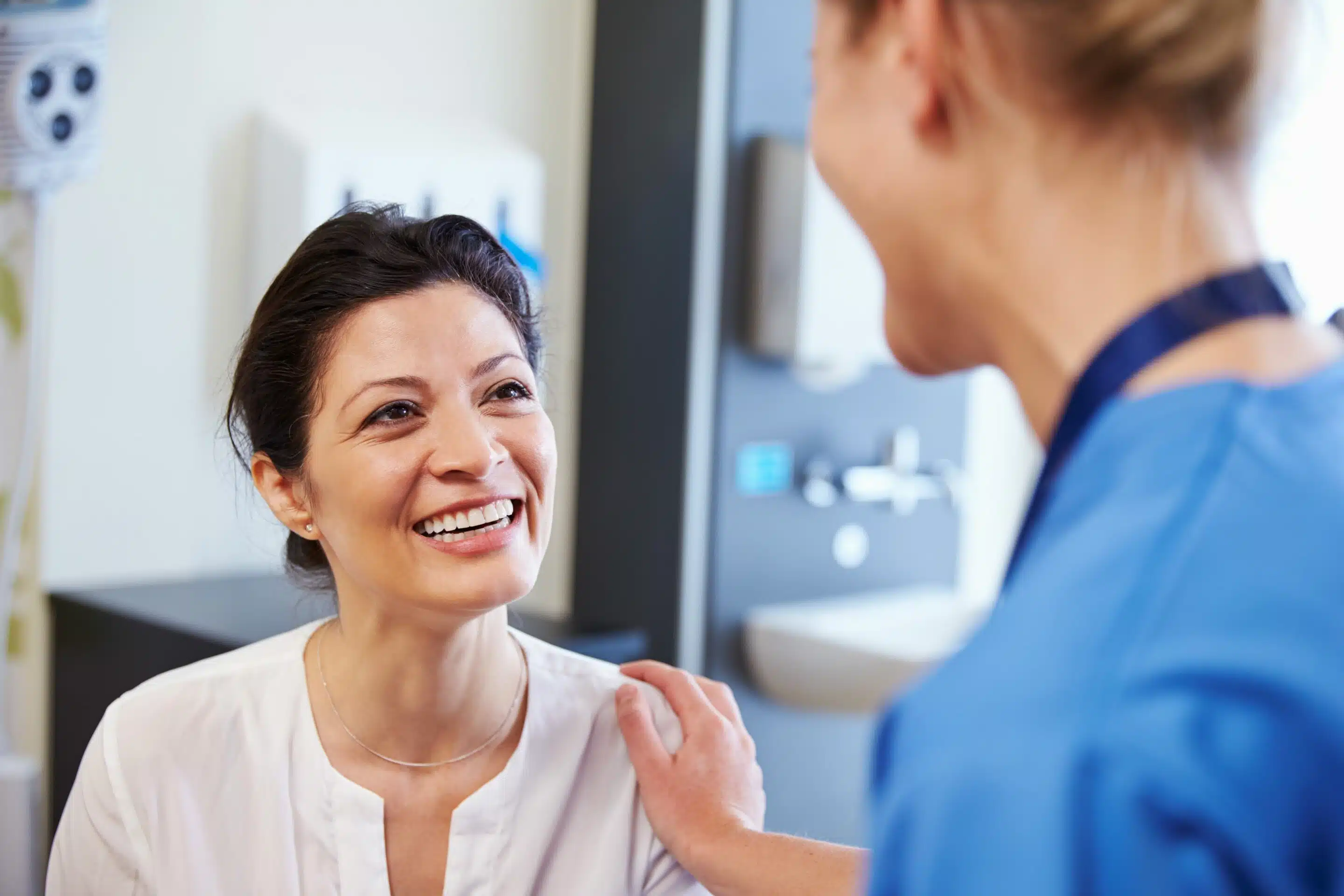 Female Patient Being Reassured By Doctor In Hospital Room iSpine treats patients with chronic pain care
