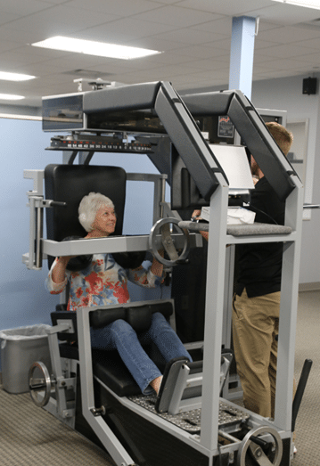 Patient utilizing MedX equipment with guidance from iSpine Clinics therapist: