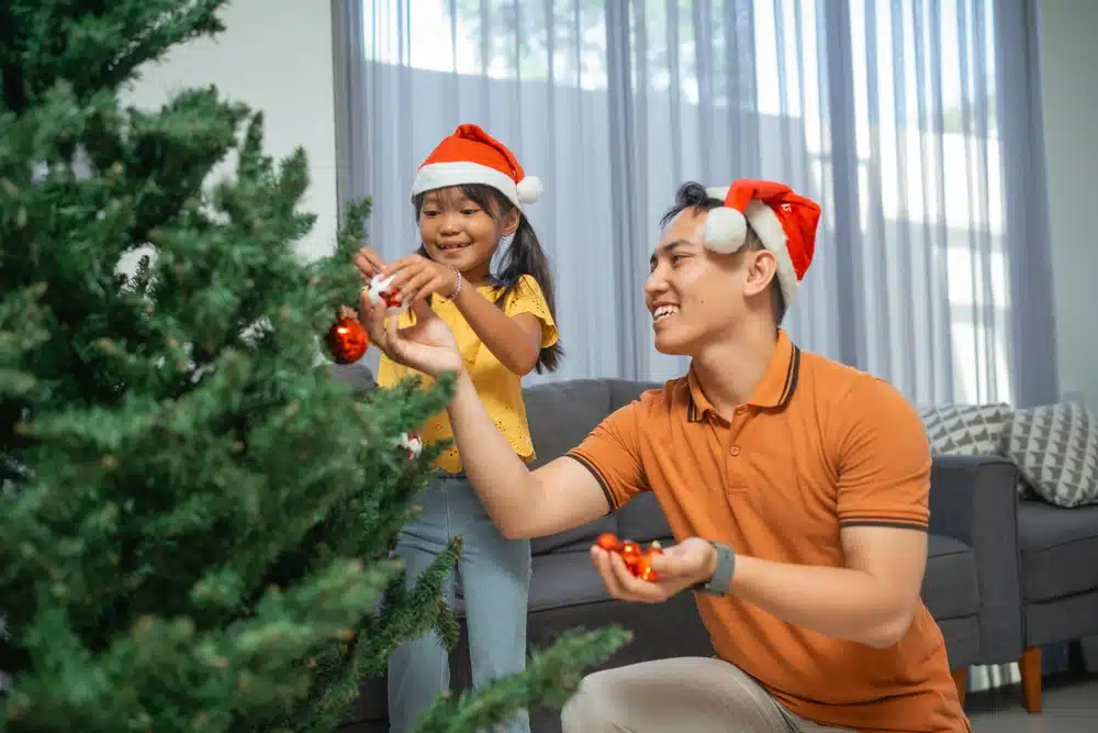 Father and daughter decorating Christmas tree together