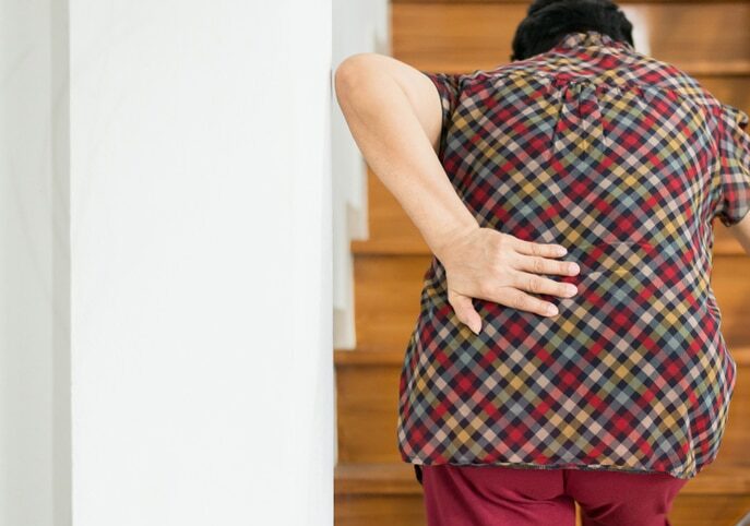 Woman on stair experiencing pain when stepping up